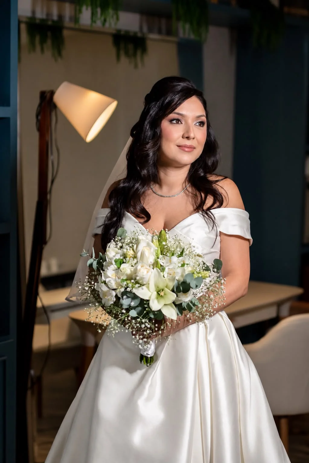 Noiva com buquê e maquiagem suave em retrato interno