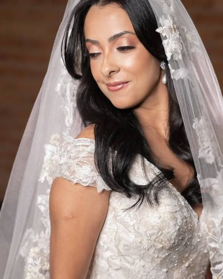 Noiva com véu, cabelo escuro e maquiagem delicada